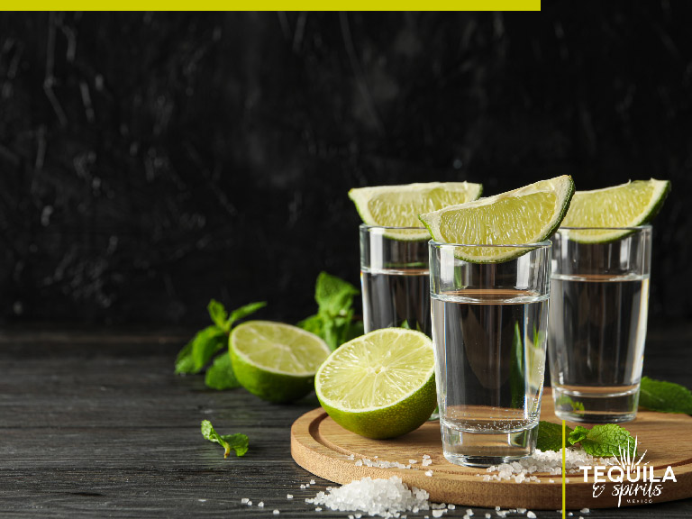 In the image there are three tequila cristalino shots with a lemon slide each one.